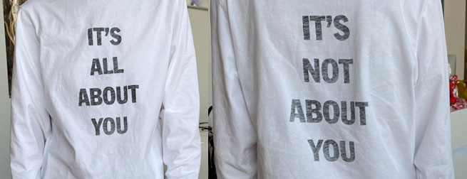 front and back of white t-shirt reading, "IT'S ALL ABOUT YOU" and "IT'S NOT ABOUT YOU," respectively